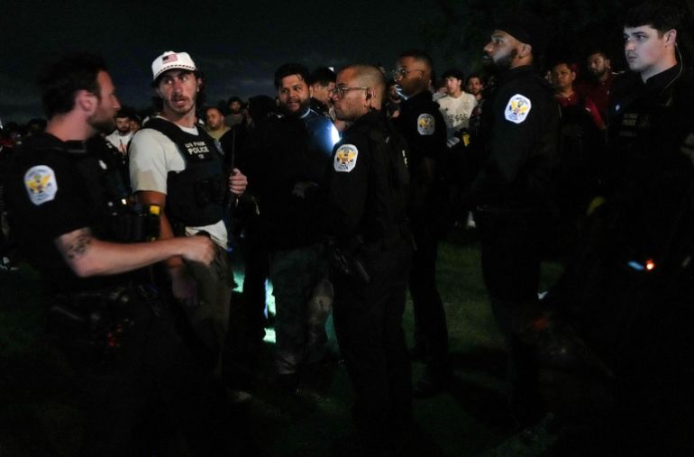 reuters_6a2fa3fc-1781507068 Law enforcement agents detain a man as fans watch a match during UFC Freedom 250 from a street across the Ellipse next to the Washington Monument, in Washington, D.C., U.S., June 15, 2026. REUTERS/Leah Millis REFILE - ADDING EVENT NAME