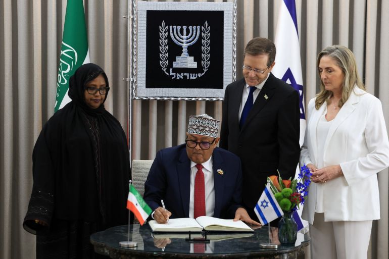 reuters_6a303da0-1781546400 Somaliland's President Abdirahman Mohamed Abdullahi signs a guest book, next to Israel's President Isaac Herzog and Israel's first lady Michal Herzog, during his visit to the President's Residence in Jerusalem, June 14, 2026. REUTERS/Ronen Zvulun