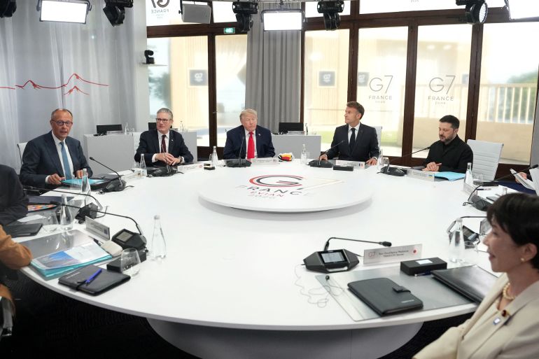 reuters_6a33fa13-1781791251 FILE PHOTO: German Chancellor Friedrich Merz, British Prime Minister Keir Starmer, U.S. President Donald Trump, French President Emmanuel Macron, Ukrainian President Volodymyr Zelenskyy and Japan’s Prime Minister Sanae Takaichi during a working session at the G7 summit in Evian-les-Bains, France, June 16, 2026. Thibault Camus/Pool via REUTERS/File Photo