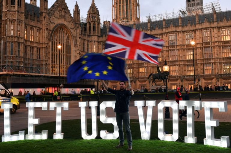FILE PHOTO: An anti-Brexit protester waves an EU and a Union Jack flag outside the Houses of Parliament in London, Britain, March 27, 2019. REUTERS/Dylan Martinez/File Photo