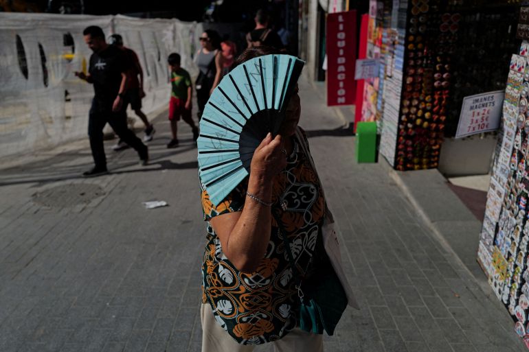 reuters_6a371f0b-1781997323 FILE PHOTO: A woman holds a fan as she walks during a spring heatwave in Madrid, Spain, May 27, 2026. REUTERS/Kacper Pempel/File Photo