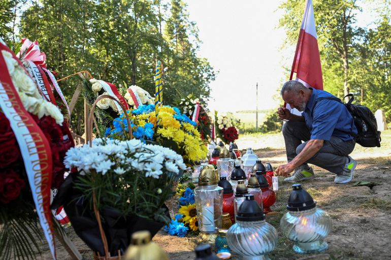 reuters_6a37a8bc-1782032572 FILE PHOTO: A man holding a Polish national flag with coat of arms lights a candle at the site of a mass burial ceremony of Poles killed by Ukrainian nationalists during World War II in the former Polish village of Puznyky, in Ternopil region, Ukraine September 6, 2025. REUTERS/Anastasiia Smolienko/File Photo