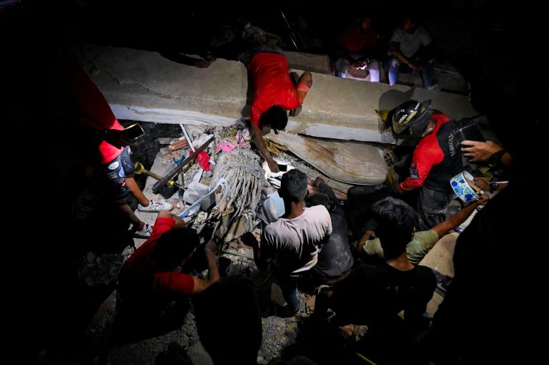 People gather as emergency workers and residents search for victims after earthquakes, in La Guaira, Venezuela, June 25, 2026. REUTERS/Maxwell Briceno
