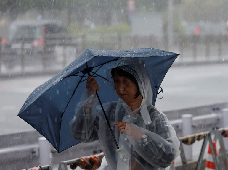 A pedestrian walks through heavy rain brought by Typhoon Jangmi in Tokyo, Japan, June 3, 2026. REUTERS/Kim Kyung-Hoon