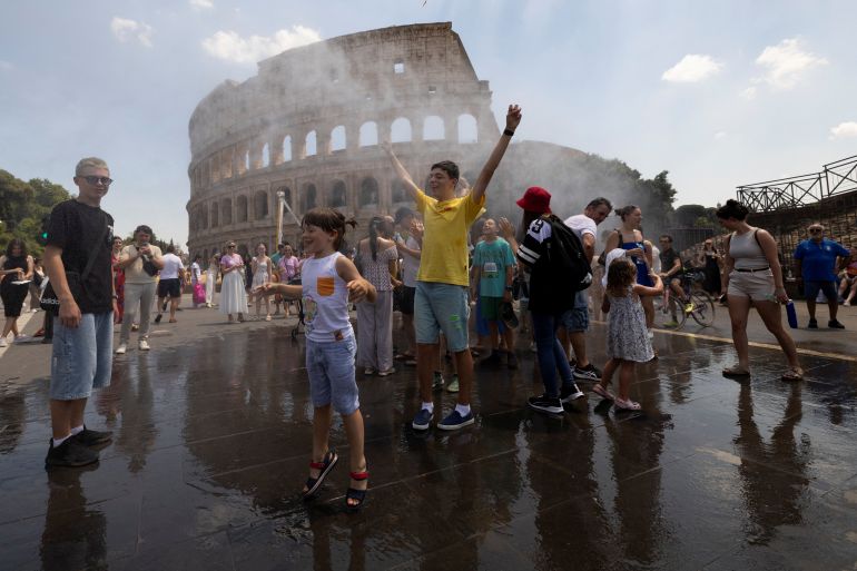 People cool off under a water mist near the Colosseum as Italy’s Civil Protection deploys measures to help residents and tourists cope with a heatwave, in Rome, Italy, June 26, 2026. REUTERS/Remo Casilli