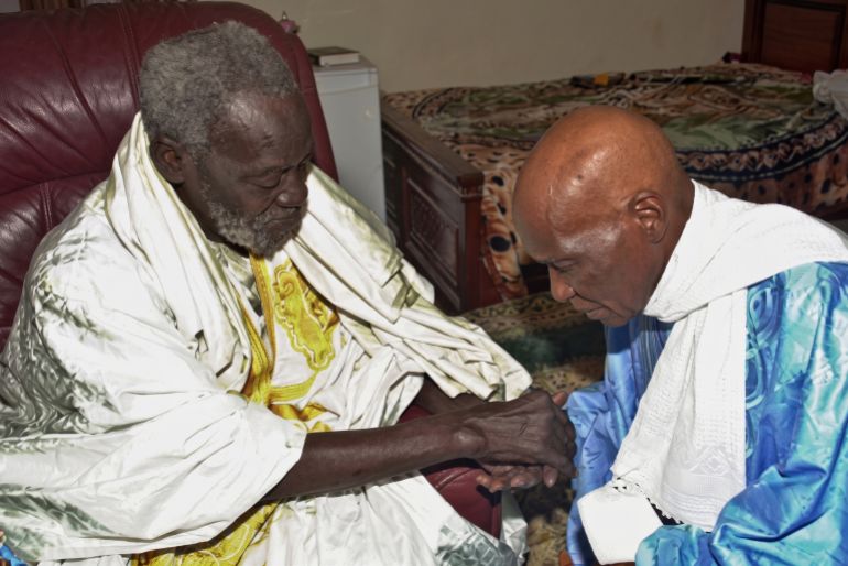 afp : (FILES) A picture taken 01 March 2001 shows Senegalese President Abdoulaye Wade (R) consulting his marabout (spiritual guide), Serigne Saliou Mbacke in Touba,