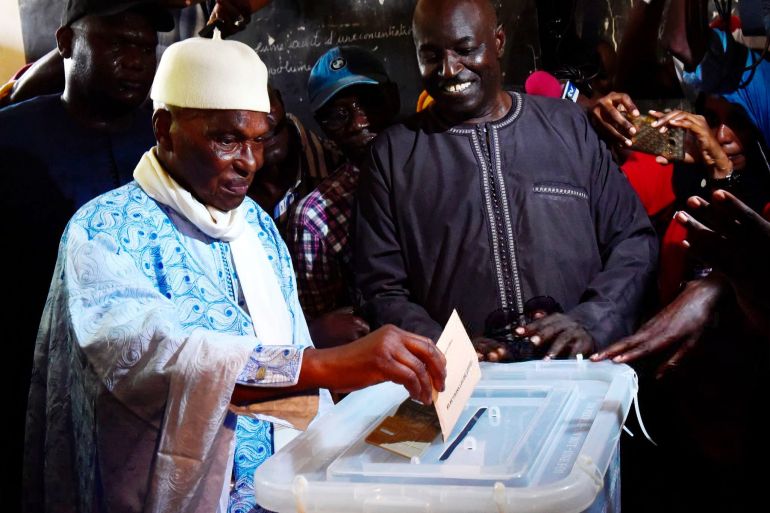 Former Senegal's president and candidate for the legislative elections Abdoulaye Wade (1st-L) prepares to cast his ballot in Dakar on July 30, 2017. Senegal holds a legislative election on July 30 following a campaign gripped by tension between the rival coalitions of President Macky Sall, his predecessor Abdoulaye Wade and Dakar's detained mayor. / AFP PHOTO / SEYLLOU (Photo credit should read SEYLLOU/AFP via Getty Images)
