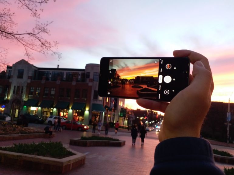 shutterstock_1369137284-1780847177 Hand holding a smartphone and taking a picture of a red sky in the evening. Bloomington, Indiana, April 10, 2019
