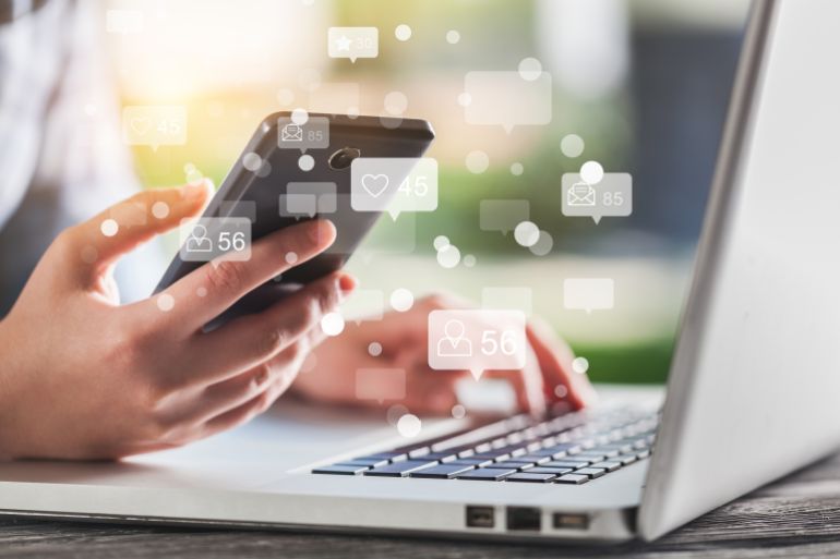 Social media and Marketing virtual icons screen concept.close up of businessman typing keyboard with laptop computer on wooden desk in modern office