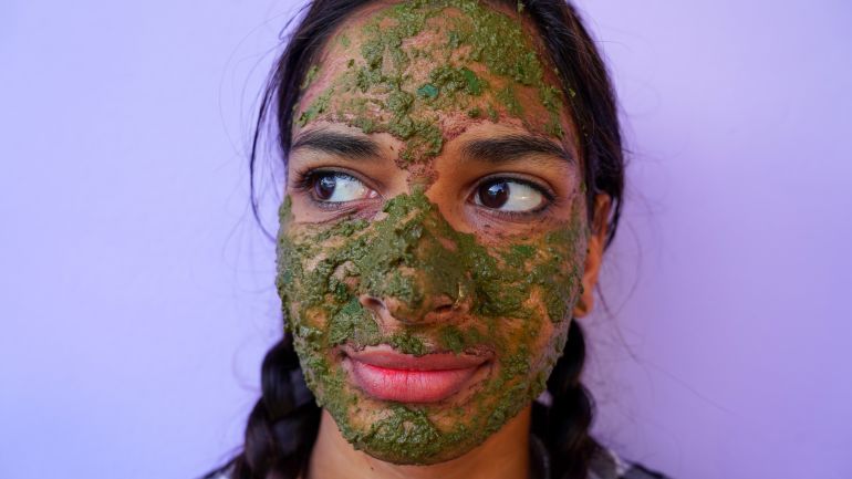 shutterstock_1921490942-1780907346 Portrait of Female with homemade facial scrub during corona virus in India. Woman using Neem herb face pack