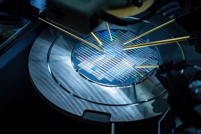 shutterstock_2126819726-1780318107 Printed circuit boards production. Robot makes Printed circuit boards. Automated chip manufacturing. Making microchips. PCB assembly. Research microchip transistor in lab. Chip manufacturing close up