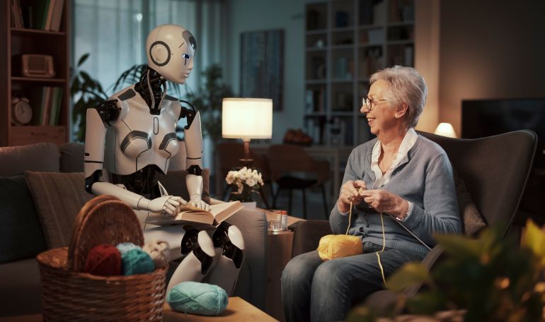 Elderly woman knitting on a sofa with her companion android reading a book in the living room. Concept of elderly care and future.
