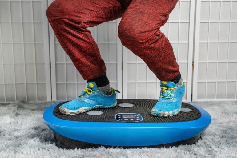shutterstock_2291253173-1780910838 man standing on a vibration plate exercise machine, full body vibration for rehabilitation and recovery