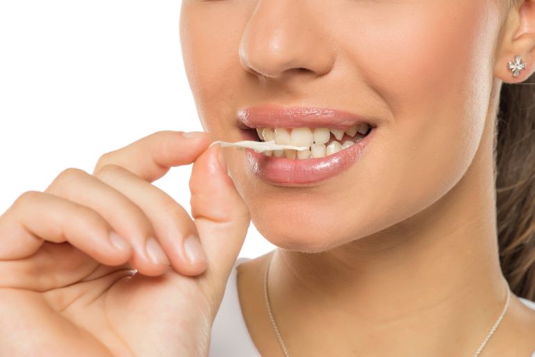 Closeup portrait of a young woman with chewing gum in her teeth