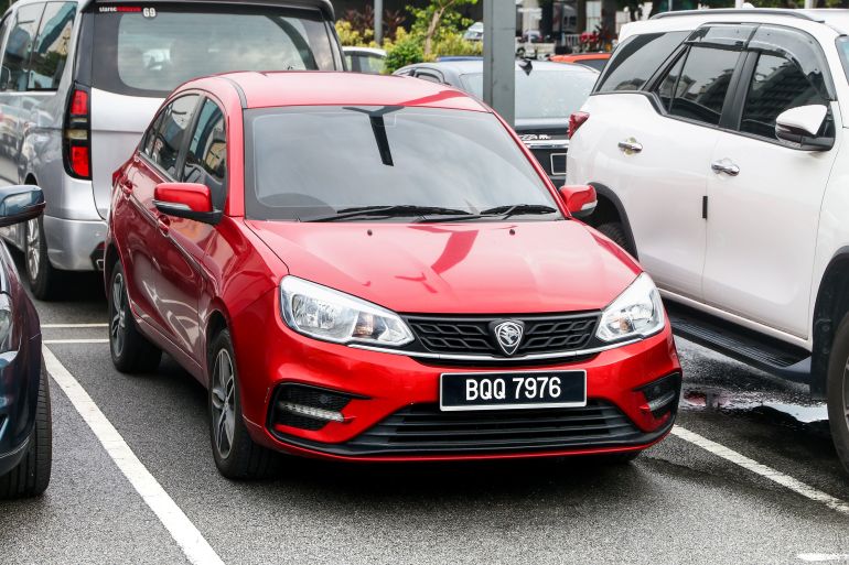 shutterstock_2497990949-1780899792 Kuala Lumpur, Malaysia - July 9, 2024: Red Malaysian car Proton Saga in the city street.