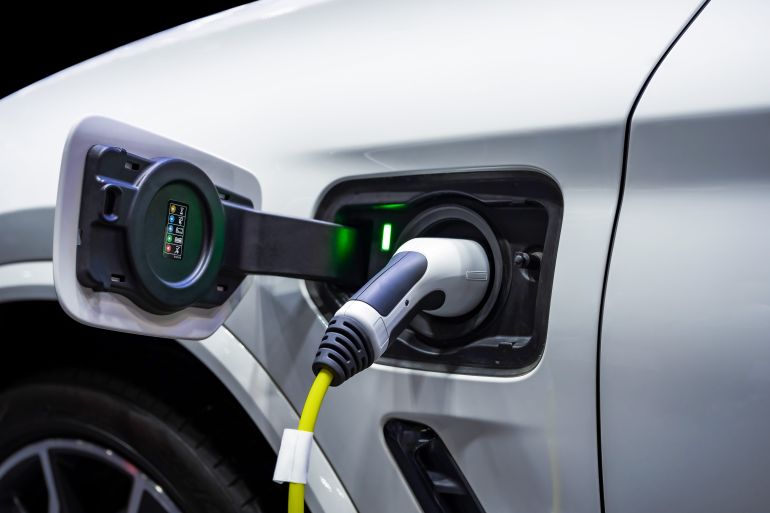 shutterstock_2610257847-1781085006 Power cable pump plug in charging power to electric vehicle EV car.