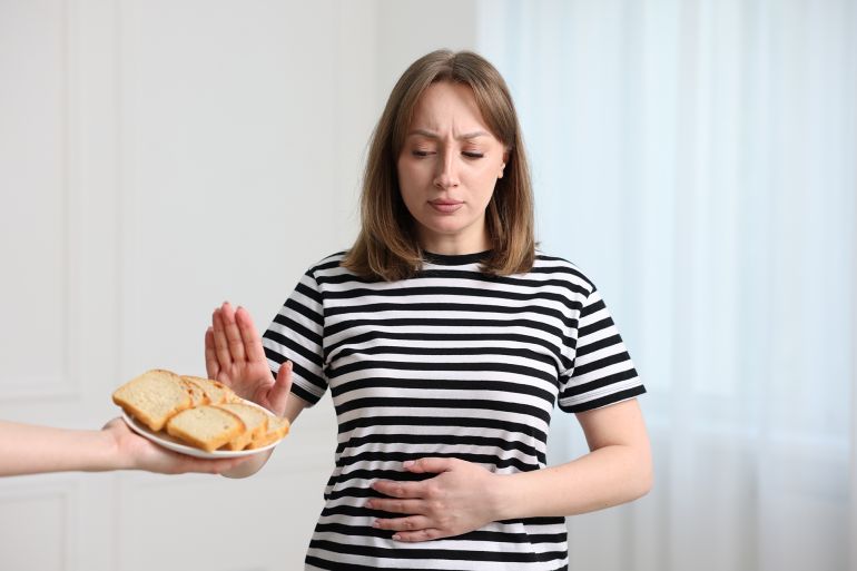 shutterstock_2650449435-1766590038 Gluten free diet. Woman refusing from bread indoors; Shutterstock ID 2650449435; purchase_order: aj; job: ; client: ; other: