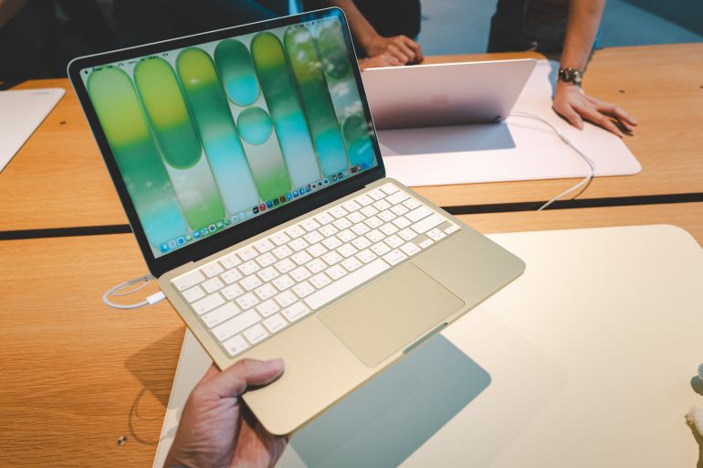 shutterstock_2757902677-1780998799 BANGKOK, THAILAND MARCH 21 2026: A group of customers explore and test the features of the new MacBook Neo at Apple Store.