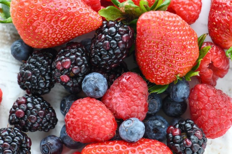 twt-frawlt-1781122824 A vibrant close-up of fresh strawberries, raspberries, blackberries, and blueberries.