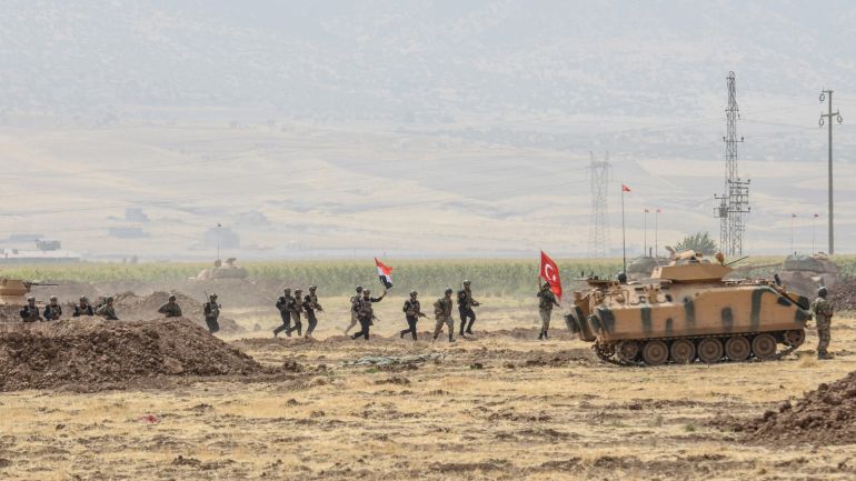 Soldiers holding Turkish and Iraqi flags walk near tanks during a joint military exercise near the Turkish-Iraqi border at Silopi district in Sirnak on September 26, 2017.Turkey launched a military drill with tanks close to the Iraqi border the army said, a week before Iraq's Kurdish region will hold an independence referendum on September 25. / AFP PHOTO / ILYAS AKENGIN (Photo credit should read ILYAS AKENGIN/AFP/Getty Images)