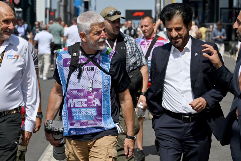 Czech Republic's President Petr Pavel (2L) walks in the paddock with FIA President Mohammed Ben Sulayem (2R) ahead of the Formula One Hungarian Grand Prix at the Hungaroring racetrack in Mogyorod near Budapest, Hungary, on July 26, 2026. (Photo by Andrej ISAKOVIC / AFP)