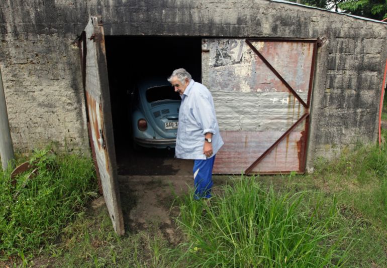 Uruguay's President Jose Mujica walks in front of his garage on his farm following an interview with Reuters, on the outskirts of Montevideo February 13, 2014. The United States and Europe need a new strategy in the war on drugs and should look at alternatives such as the regulated sale of marijuana, says Uruguayan President Mujica, whose country recently legalized the production and sale of cannabis. In an interview with Reuters on Thursday, the 78-year-old former left-wing guerrilla said the world's biggest economies, which are the biggest markets for illegal narcotics, need to tackle drug trafficking using tools other than prohibition. To match Interview URUGUAY-DRUGS/MUJICA REUTERS/Andres Stapff (URUGUAY - Tags: POLITICS DRUGS SOCIETY)
