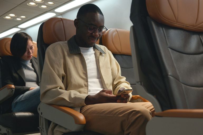 Passenger businessman using mobile phone test wifi connection in plane during flight by sorapop @ادوبي ستوك