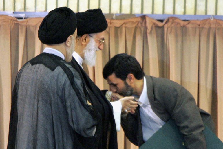 6758fgh7-1779291729 Iran's new President Mahmood Ahmadinejad (R) kisses the hand of Iranian Supreme Leader Ayatollah Ali Khamenei (C) during a ceremony to formally install the ultra-conservative former revolutionary guard as successor to outgoing president Mohamad Khatami (L), 03 August 2005 in Tehran. Ahmadinejad appealed for an end to weapons of mass destruction in the world, a day after the West issued sharp warnings to Tehran over its threatened violation of a deal suspending its nuclear programme. AFP PHOTO/ATTA KENARE (Photo by ATTA KENARE / AFP)
