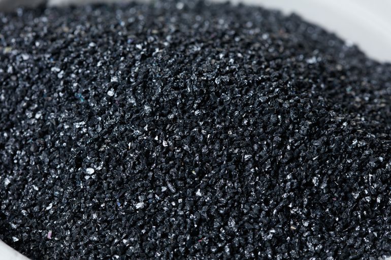 698y7-1782904107 Macro close up of Silicon Carbide black sand size. Fine particle silicon carbide pile up, White background Isolated, particle element object