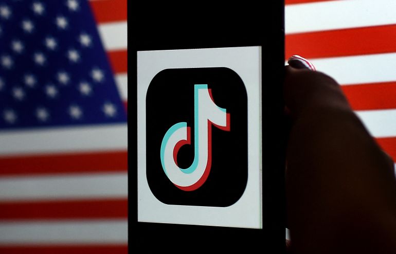 afp_69732aa0c70d-1769155232 (FILES) In this photo illustration, the social media application logo, TikTok is displayed on the screen of an iPhone on a US flag background on August 3, 2020 in Arlington, Virginia.