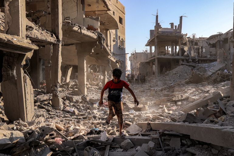 afp_6a4429e72e03-1782852071-1 TOPSHOT - A boy walks through the rubble of a building that was destroyed following Israeli bombardment after an evacuation order, at the Maghazi camp for Palestinian refugees in the central Gaza Strip on June 12, 2026.