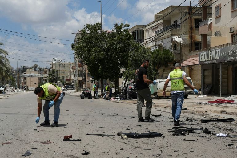 First responders inspect the site where a car was reportedly targeted by an Israeli strike in Nabatieh on July 6, 2026.