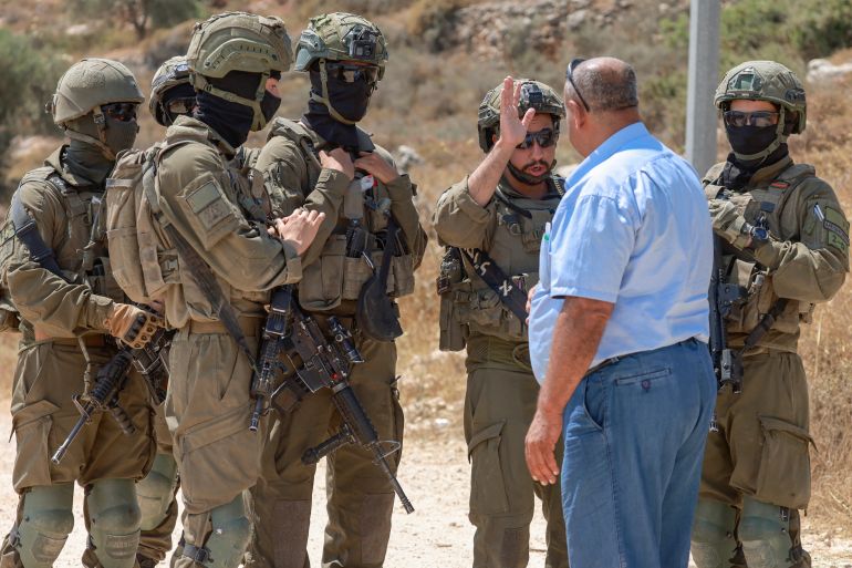 afp_6a4e191275c0-1783503122-1 A Palestinian man argues with Israeli soldiers as they prevent residents from the village of Qabalan, south of Nablus in the occupied West Bank, from returning to their homes and lands after Israeli settlers, who had established an outpost on the village's land, prevented them from approaching, on July 4, 2026. (Photo by Jaafar ASHTIYEH / AFP)