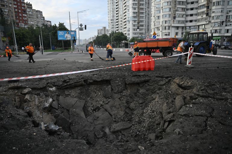 afp_6a53a1b1de89-1783865777 Communal workers clean around a crater from Russian missile strikes on the Ukrainian capital of Kyiv early on July 11, 2026, amid the Russian invasion in Ukraine.