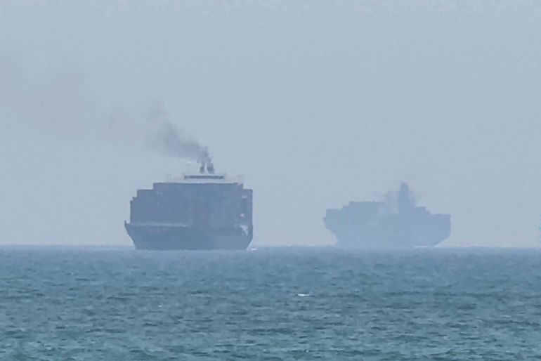 afp_6a54de6d9063-1783946861 TOPSHOT - This frame grab taken from AFPTV video footage on July 12, 2026 shows cargo ships anchoring near the Strait of Hormuz off the eastern coast of the United Arab Emirates at Khor Fakkan.