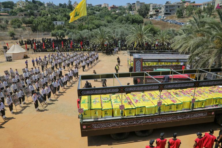 afp_6a5c067c9fa3-1784415868 The caskets of Hezbollah fighters killed during clashes with the Israeli army are pictured to the right and left of a mock coffin of Iran's slain supreme leader, Ayatollah Ali Khamenei during a mass funeral in the southern Lebanese village of Majdel Selm on July 18, 2026.