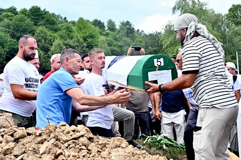 Bosnian Muslims bury a casket containing the remains of victims of the 1995 Srebrenica massacre at the memorial cemetery in the village of Potočari, near Eastern-Bosnian town of Srebrenica, on July 11, 2026, marking the 31st anniversary of Srebrenica genocide.