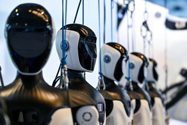 afp_6a5dfae824bd-1784543976 Humanoid robots by OpenMind Robotics are seen during the World Artificial Intelligence Conference (WAIC) in Shanghai on July 18, 2026. (Photo by Hector RETAMAL / AFP)