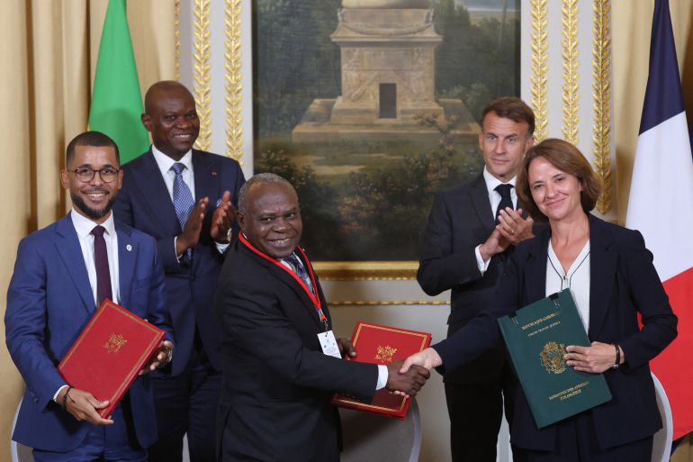 afp_6a5f45e2eed2-1784628706 Gabon's President Brice Oligui Nguema (2ndL) and France's President Emmanuel Macron(2ndR) applaud after EDF Group Senior Executive Vice-President/CEO of EDF Group/EDF Power Solutions Beatrice Buffon (R); CEO of Gabon Power Company (GPC) Phillipe Junior Ossoucah (L) and Gabon's Minister of universal access to water and energy Philippe Tonangoye signed a Commitment Protocol related to Development of the Booué Hydroelectric Project on the sidelines of the state visit of Gabon's President at the Elysee Palace in Paris on July 20, 2026. (Photo by Ludovic MARIN / POOL / AFP)
