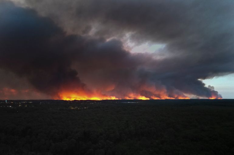 afp_6a6313637fc2-1784877923 This aerial view shows a residential area engulfed in flames during a wildfire in the forest of Lege-Cap-Ferret, southwestern France on July 23, 2026, after residents were evacuated as the blaze threatened homes.