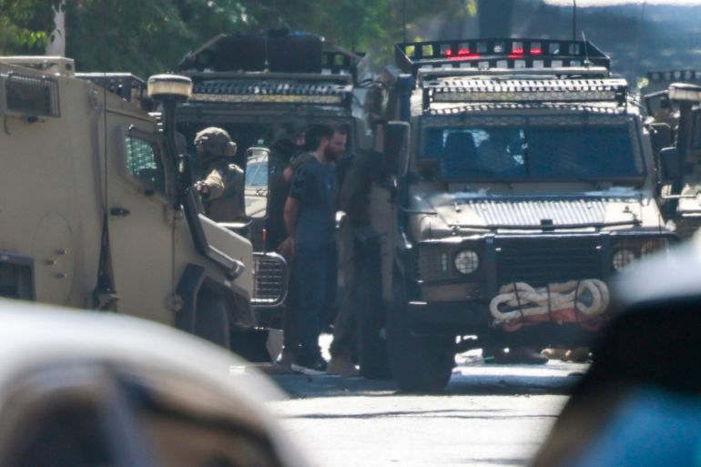 EDITORS NOTE: Graphic content / Israeli soldiers detain a man as they surround the Nablus Specialized Hospital where they allegedly arrested a wounded man and his brother from inside the hospital in Nablus, in the occupied West Bank on July 24, 2026.
