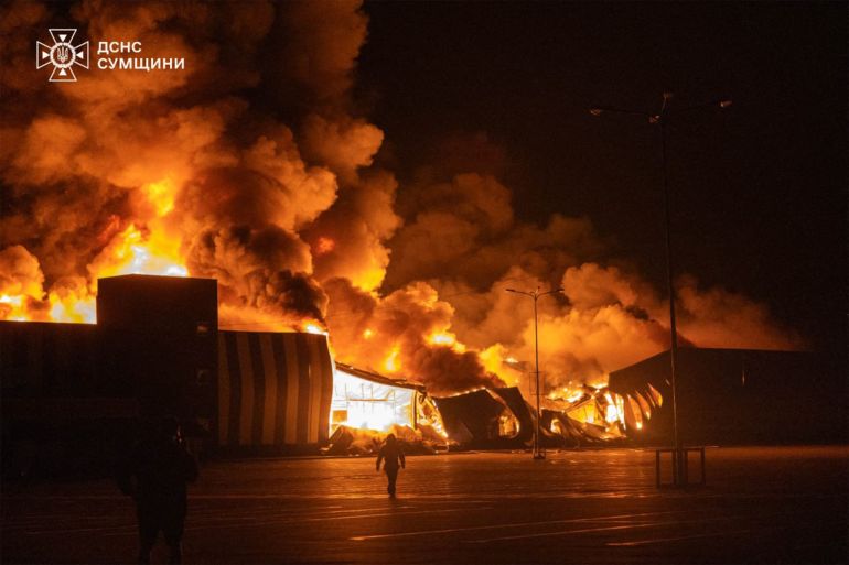 TOPSHOT - This handout photograph taken and released by the State Emergency Service of Ukraine on July 21, 2026, shows firefighters working to extinguish a fire at the site of a drone strike on a shopping center in Sumy, amid the Russian invasion of Ukraine. (Photo by Handout / STATE EMERGENSY SERVICE OF UKRAINE / AFP) / RESTRICTED TO EDITORIAL USE - MANDATORY CREDIT "AFP PHOTO / STATE EMERGENCY SERVICE OF UKRAINE" - HANDOUT - NO MARKETING NO ADVERTISING CAMPAIGNS - DISTRIBUTED AS A SERVICE TO CLIENTS