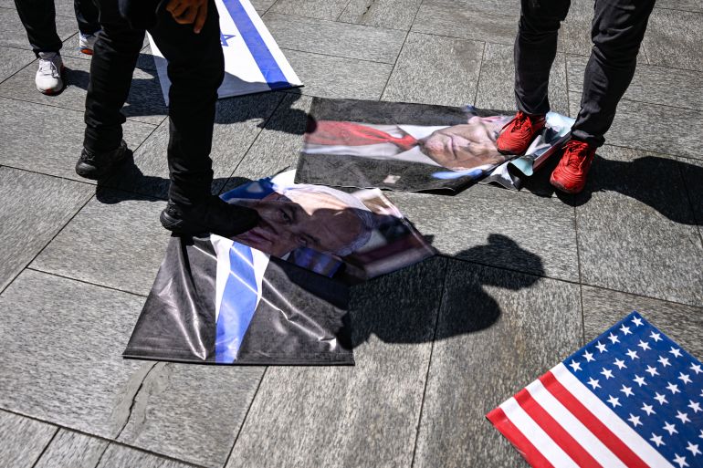 afp_6a646c247043-1784966180 Protesters trample on photographs of Israeli Prime Minister Benjamin Netanyahu and U.S. President Donald Trump, along with Israeli and U.S. flags during a rally in Caracas on July 24, 2026, protesting the presence and influence of the United States and Israel in the country, one month after the June 24 earthquakes.