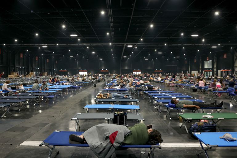 afp_6a64bb0ebdbf-1784986382 TOPSHOT - Local residents rest at the Parc des Expositions de Bordeaux after being evacuated due to wildfires in the region, in Bordeaux, on July 25, 2026.