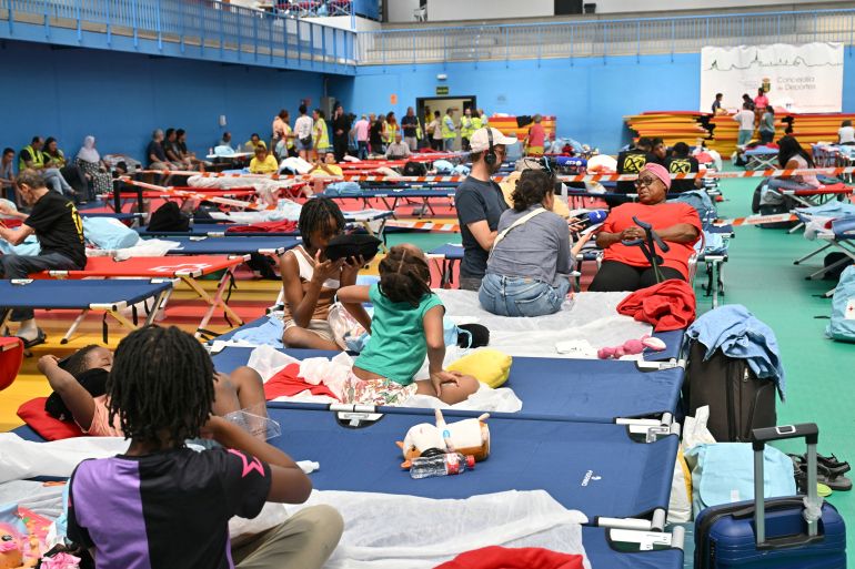 afp_6a64bb6912b5-1784986473 Evacuees rest in a sports hall in Villaviciosa de Odon, 20 kms west of Madrid, on July 25, 2026 amid wildfires that have burned up to 25,000 hectares.