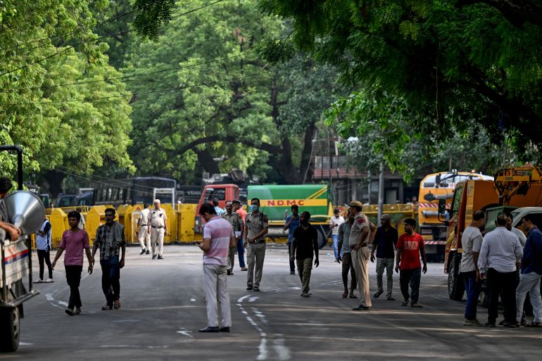 afp_6a66a4f15c7e-1785111793 Workers and police officials walk at the Jantar Mantar after the Cockroach Janta Party (CJP) ended their month-long protest in New Delhi on July 26, 2026.