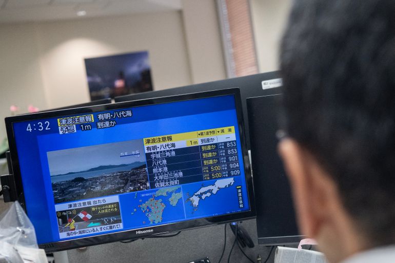 Reporters watch the news showing a large quake and possible one meter tsunami wave in Southern Japan, from an office in Tokyo on July 28, 2026.