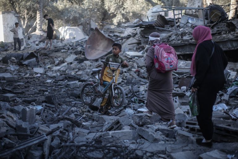 Palestinians inspect damaged and destroyed buildings after they were targeted by Israeli strikes the previous night following warnings to evacuate in Deir al-Balah, central Gaza Strip on July 29, 2026.