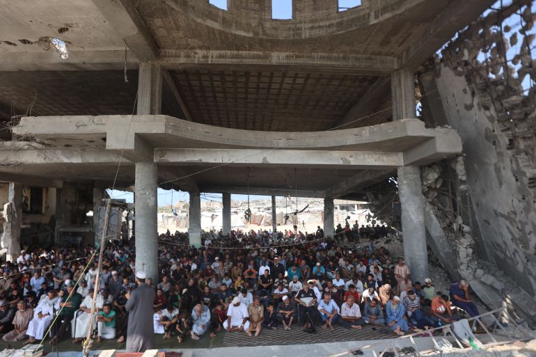 Palestinian Muslim worshippers attend friday prayers amidst the rubble of the destroyed Albaani Mosque in Khan Yunis in the southern Gaza Strip on October 17, 2025. Hamas said it was committed to the US-brokered agreement that halted its war with Israel, and to returning all the bodies of hostages still unaccounted for under the ruins of Gaza. (Photo by Omar AL-QATTAA / AFP)