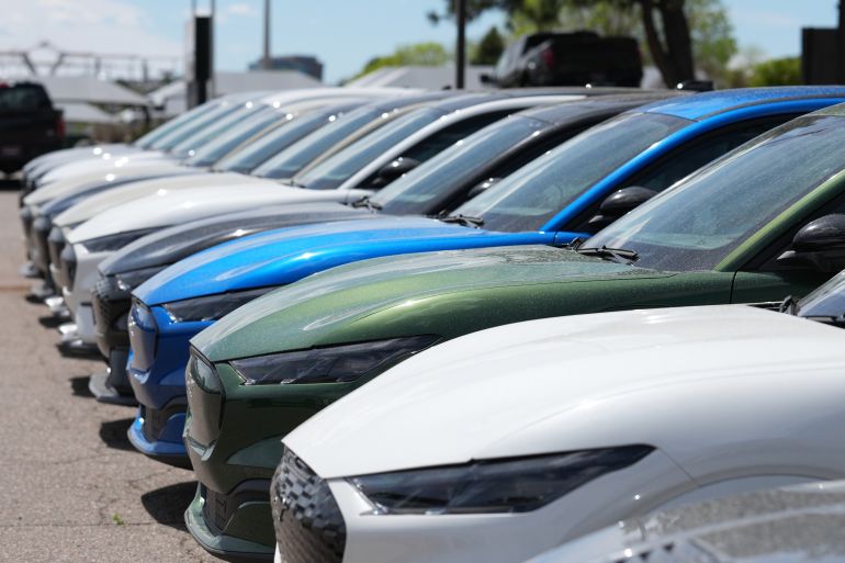ap_69ff3c1df0a74-1778334750 Unsold 2026 Mustang Mach E electric utility vehicles sit in a long line outside a Ford agency Sunday, April 12, 2026, in Centennial, Colo. (AP Photo/David Zalubowski)